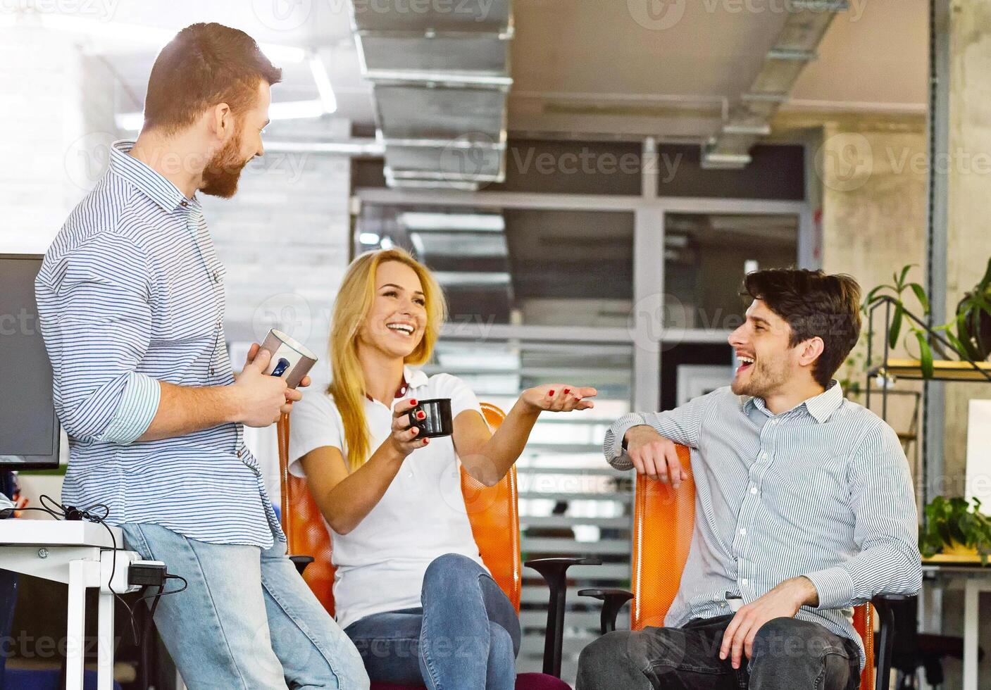 Coffee break. Young friendly colleagues talking and laughing in office, empty space photo