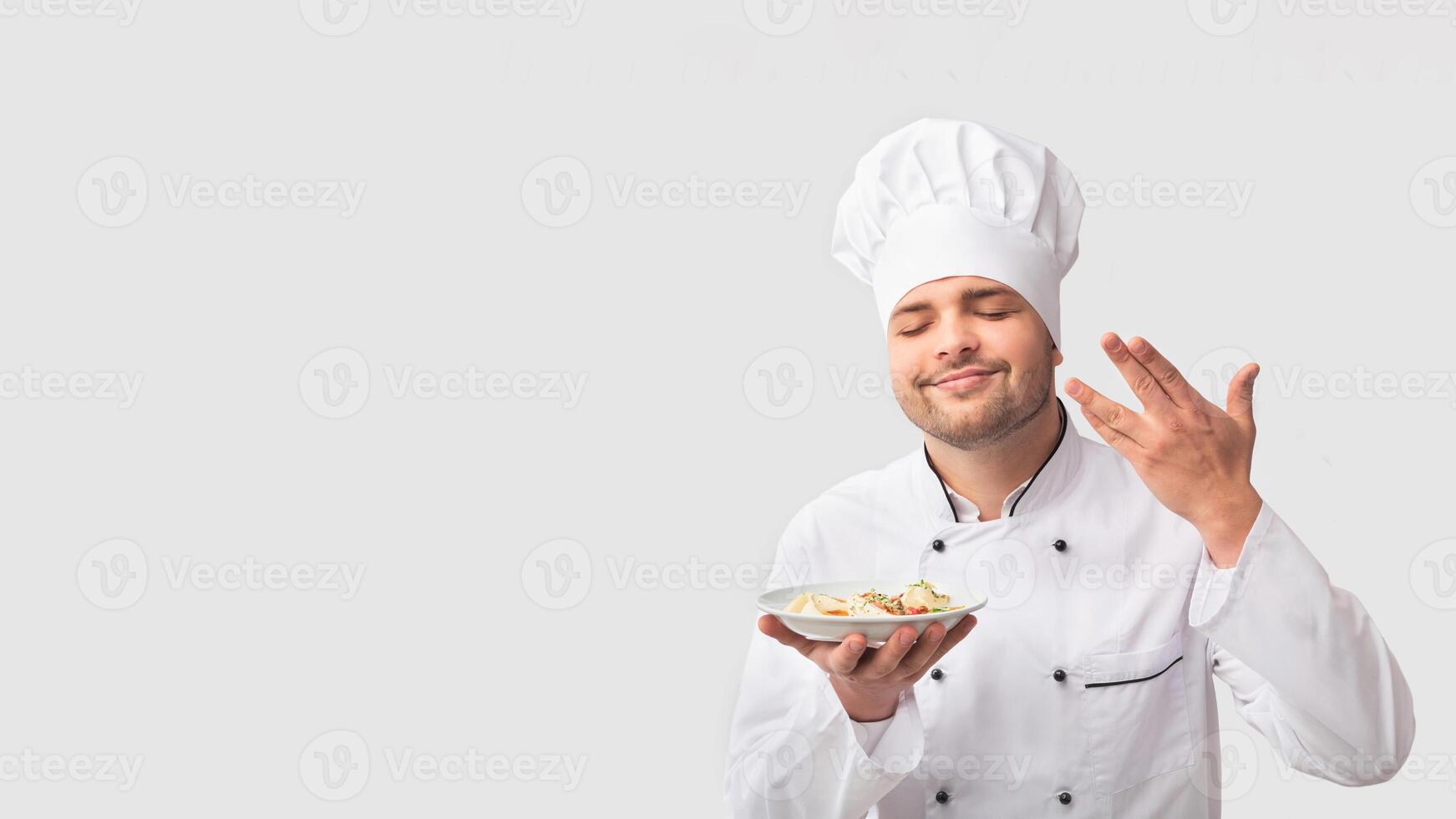 Cooking Food. Chef Man Holding Plate Smelling The Aroma Of Dish Standing Over White Studio Background. Panorama photo