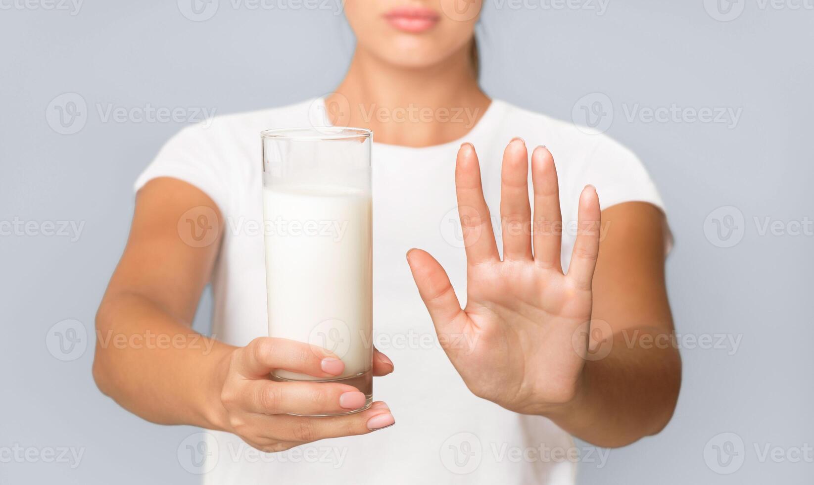 Lactose Intolerance Concept. Unrecognizable Woman Holding Milk And Gesturing No Standing In Studio On White Background. Cropped photo