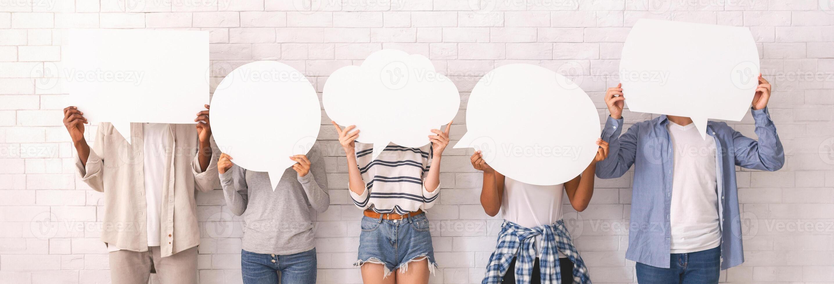 Multiracial group of teenagers in casual clothes hiding behind speech bubbles, communication concept, white background photo