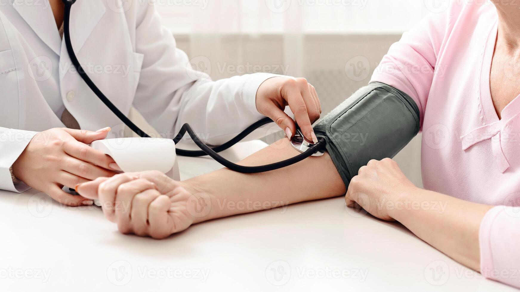 A doctor in a white coat is carefully examining a patients arm while drawing blood for a medical test. The patient looks calm and focused during the procedure. photo