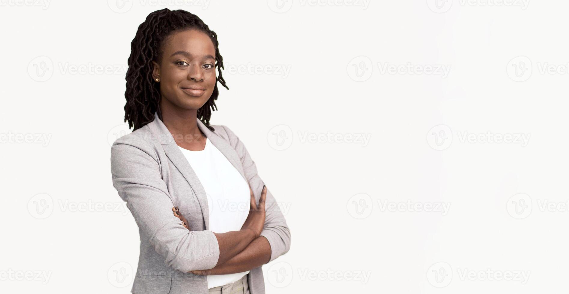 Self-confident African American corporate woman dressed in a grey blazer, isolated on a white background, with plenty of room for text. photo