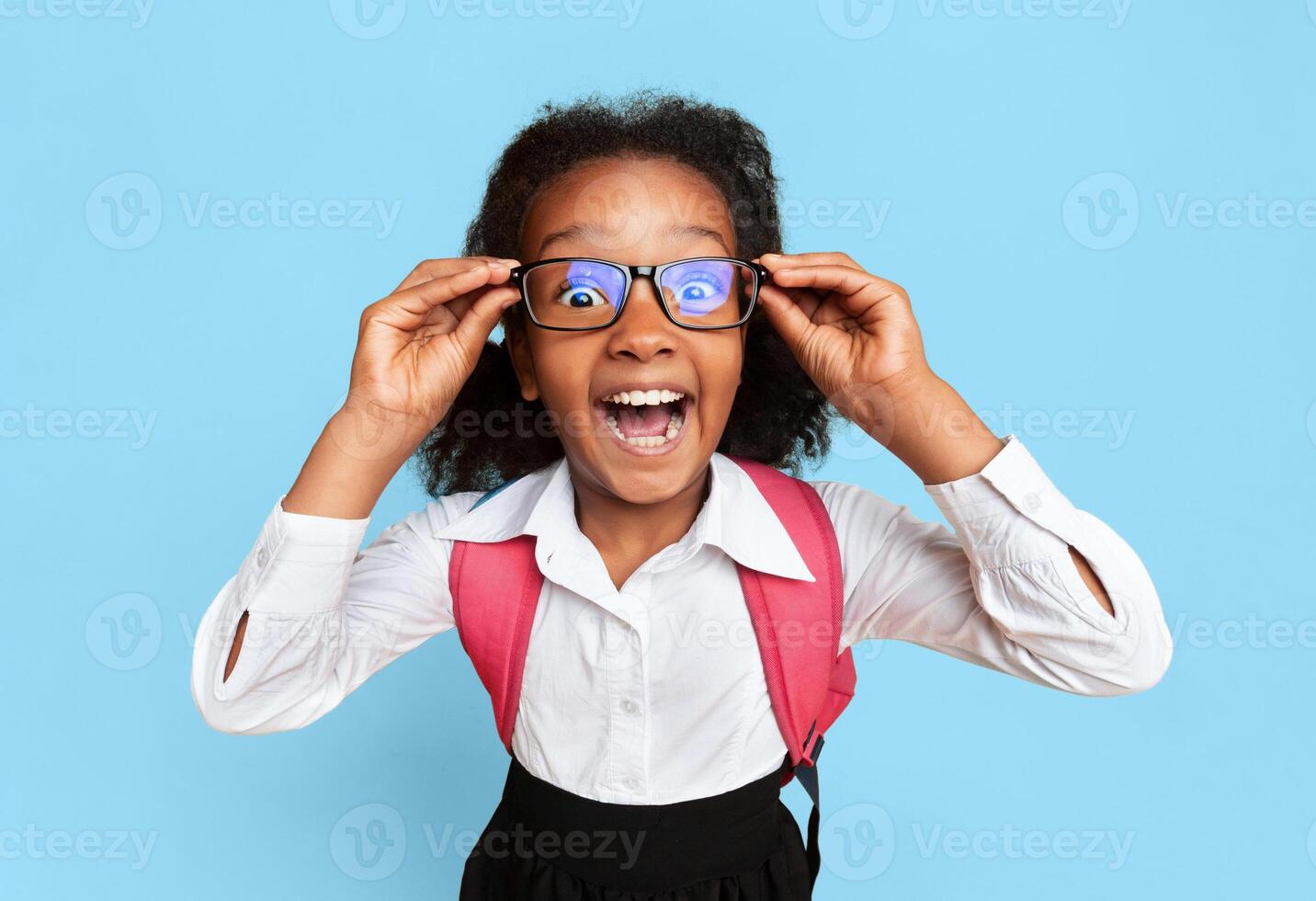 Back To School. Black Schoolgirl Screaming Looking At Camera On Yellow Background In Studio. High-Angle photo