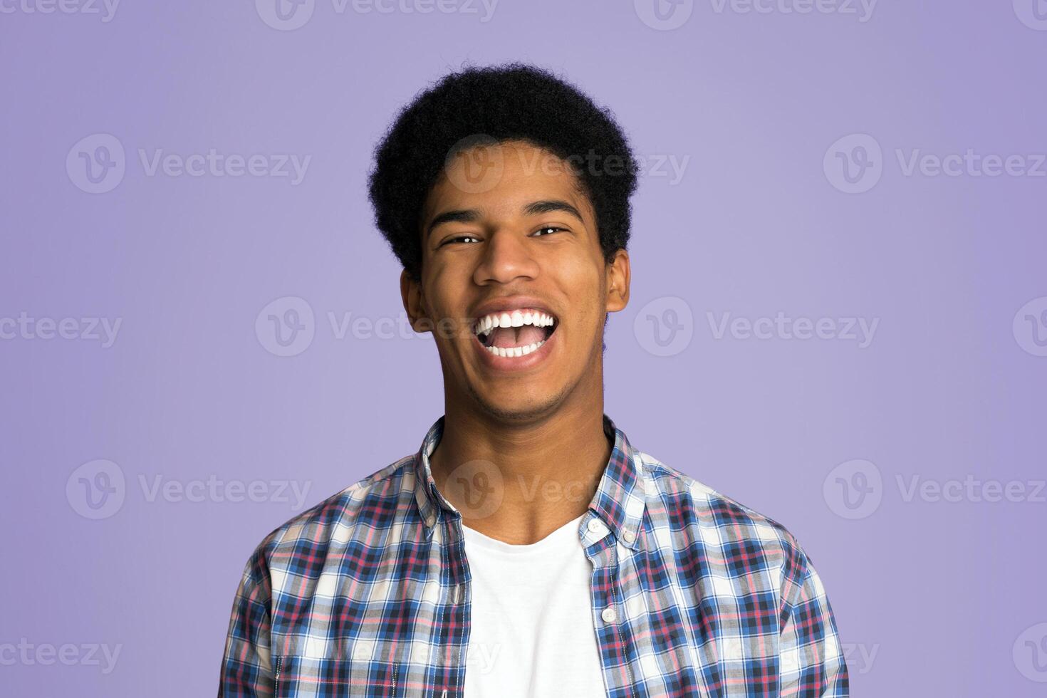 Excited guy laughing and looking at camera over pink background photo