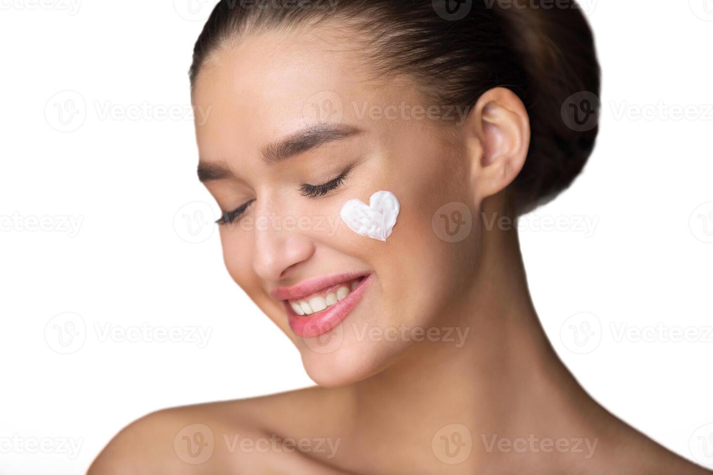 Love your Body. Woman With Cream In Hearth Shape on Cheek, Grey Background photo