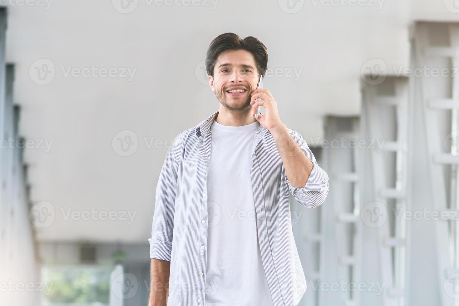 Calling he is fine. Young man talking on phone after arrival to airport, panorama with empty space photo