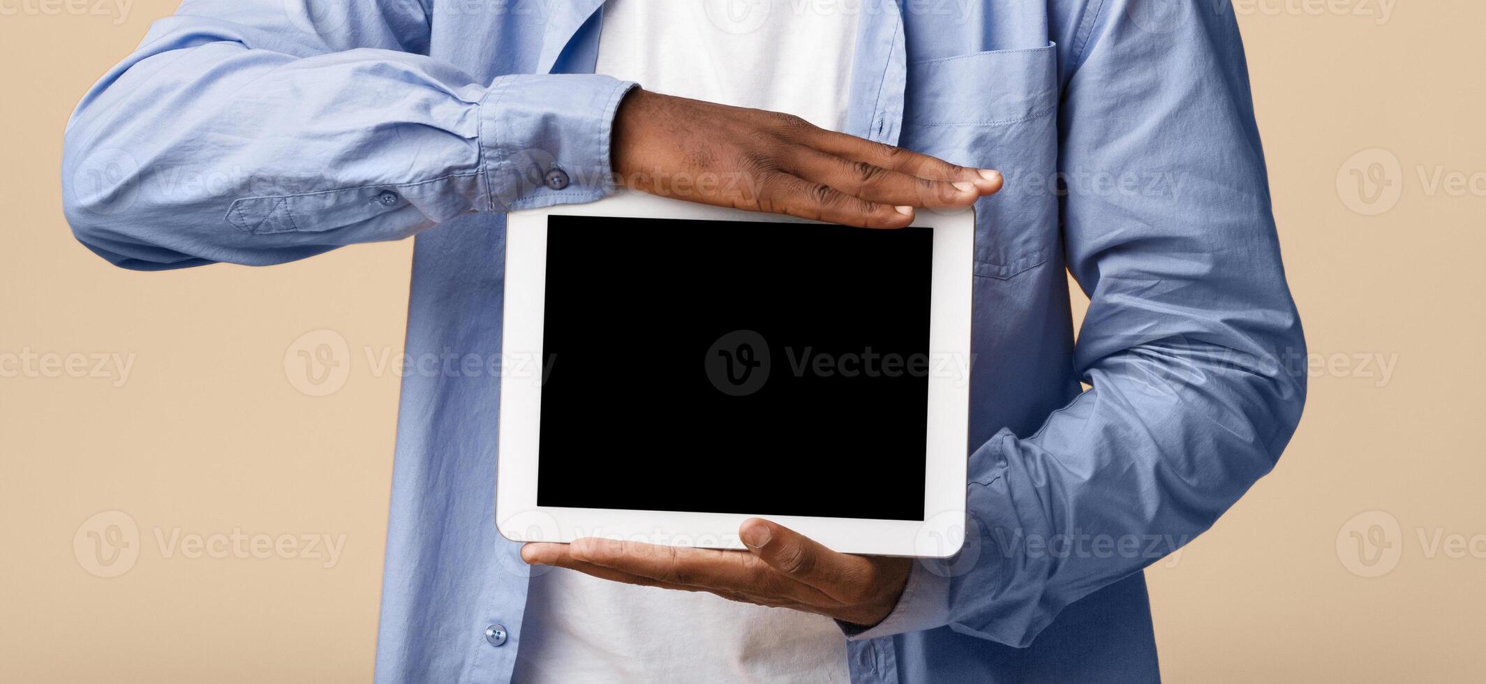 Great App. Smiling African American Man Showing Empty Tablet Screen On Yellow Background In Studio. Mockup photo