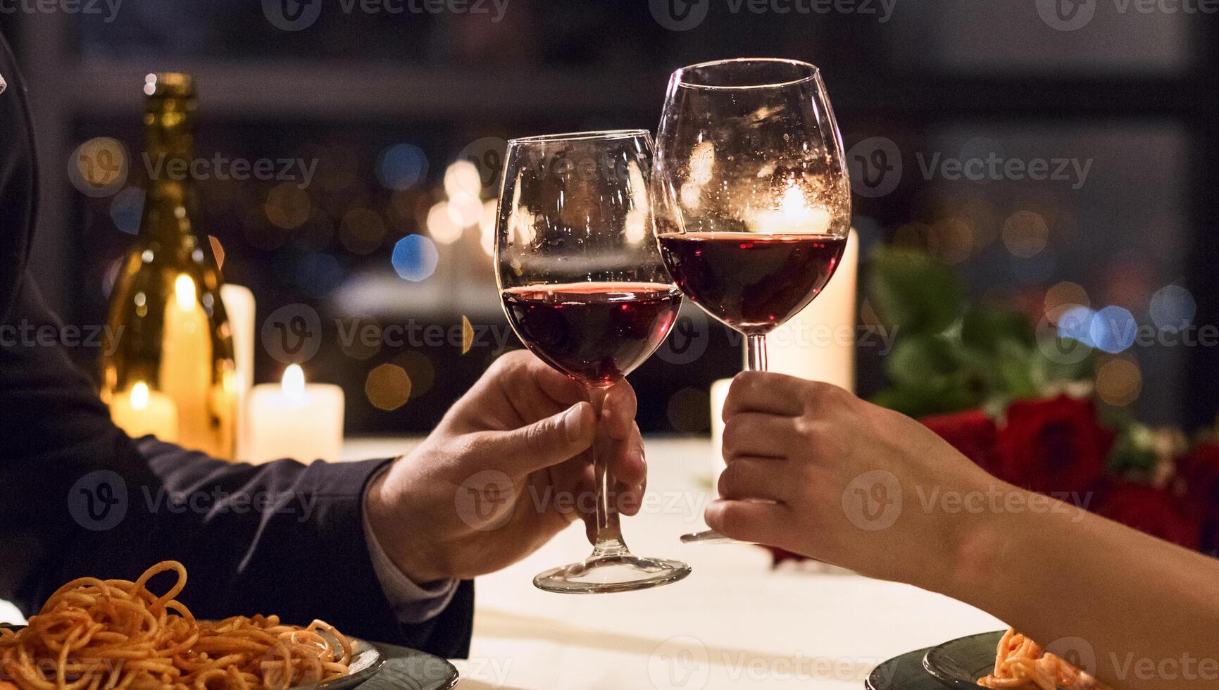 Hands holding glasses of wine on restaurant background. Let's have a toast concept photo
