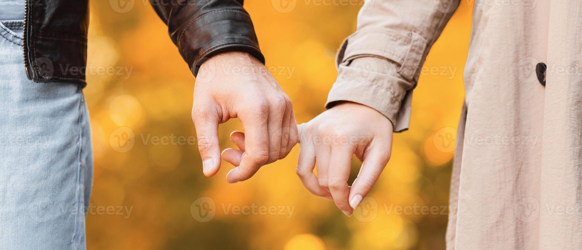 Cropped of man and woman holding fingers over autumn park background, panorama photo