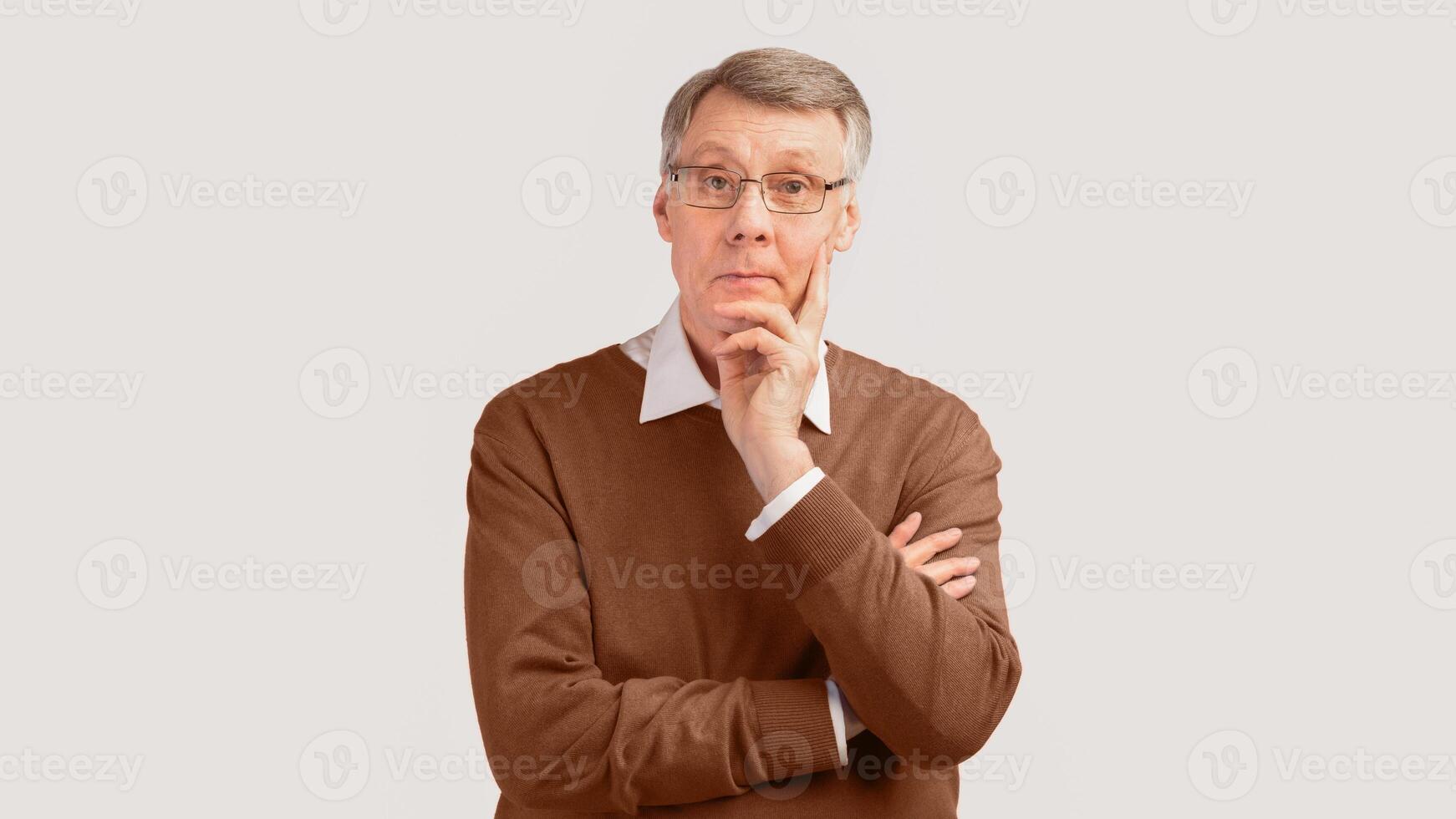 Pensive Senior Man Thinking About Something Touching Chin Standing Over Gray Studio Background. Panorama photo
