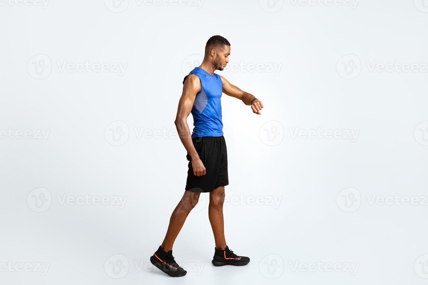 Time Limit. Full length black sports man using fitness tracker over yellow studio background, copyspace photo