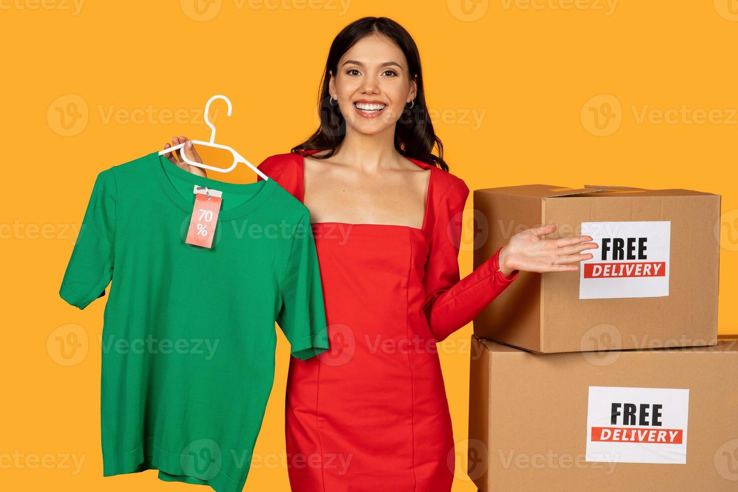 A woman is standing next to a box filled with clothes, while a sign advertising free shipping is displayed prominently. The woman appears to be examining the contents of the box photo