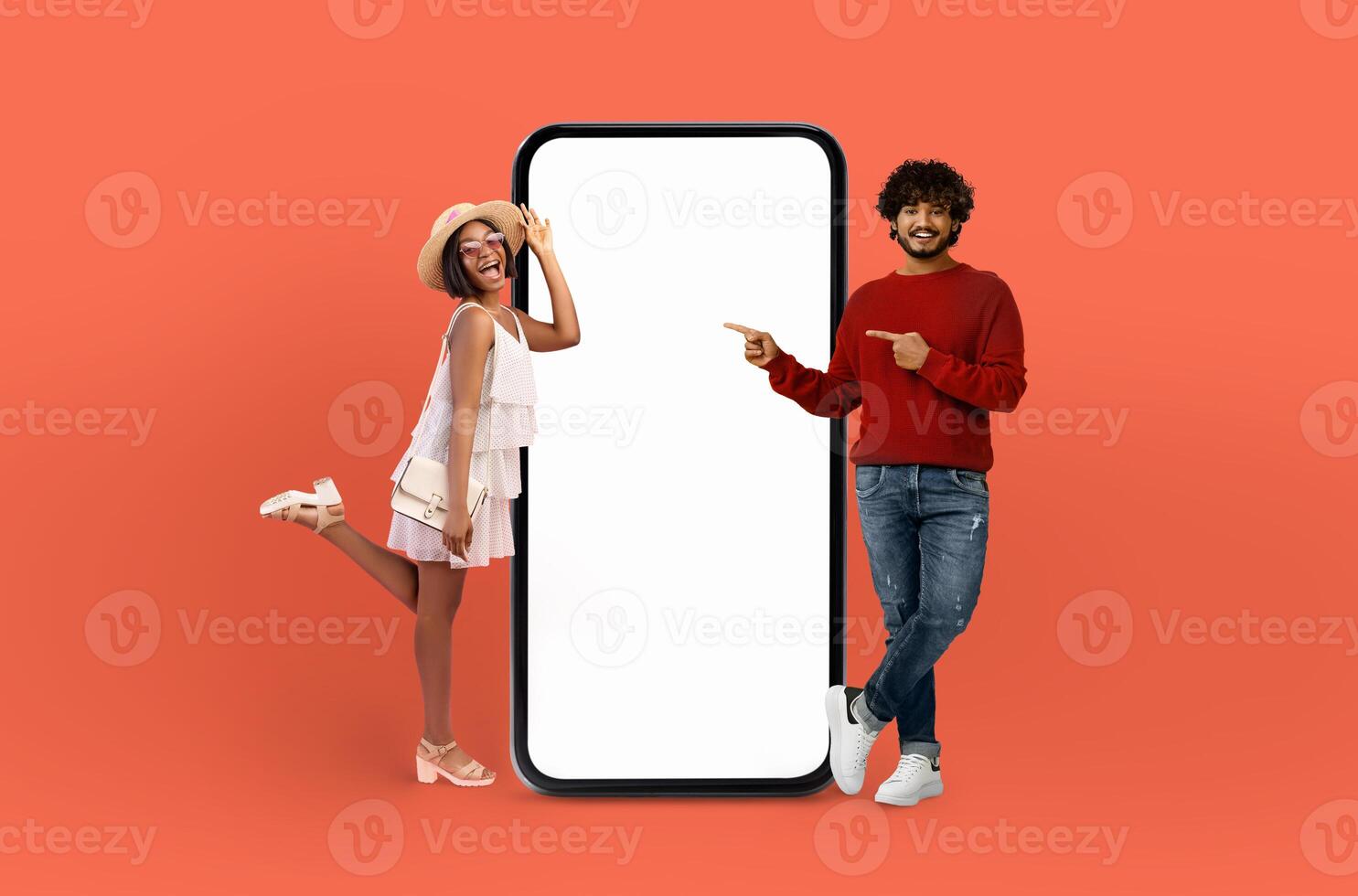 A man and woman are standing side by side next to a landline phone with a blank screen. The man appears to be talking while the woman is looking at the phone. The setting seems to be indoors. photo