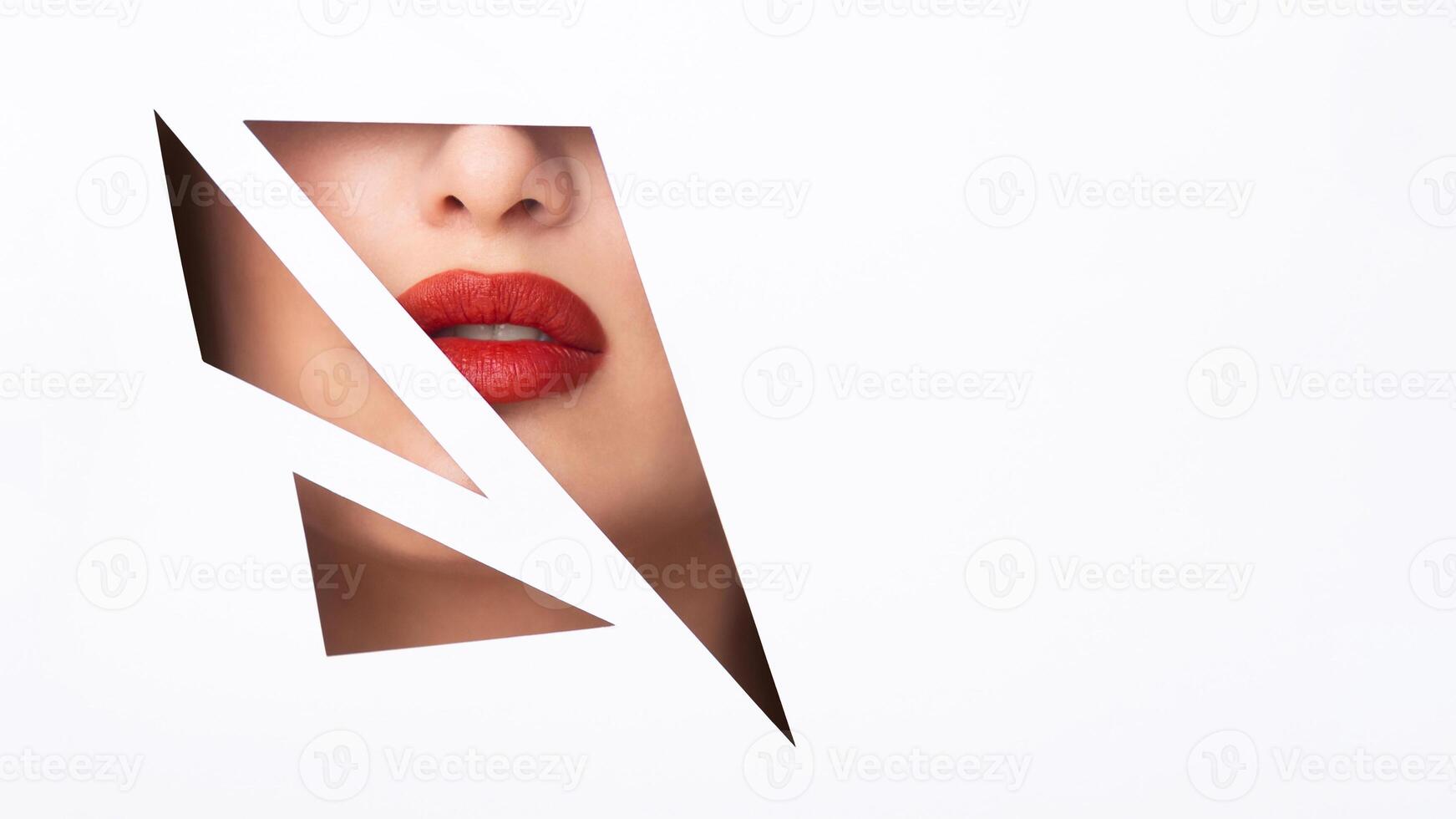 Cropped of woman face is visible through a perfectly round hole in a piece of paper, creating a unique and unexpected visual effect, copy space photo
