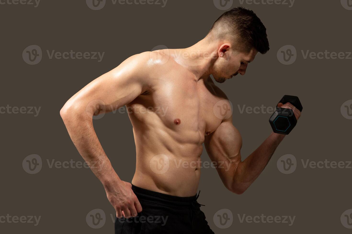 A man is holding a dumbbell in his hands, showcasing strength and fitness training. Mans muscles are visibly engaged as he lifts the weight, demonstrating dedication to physical exercise and health. photo