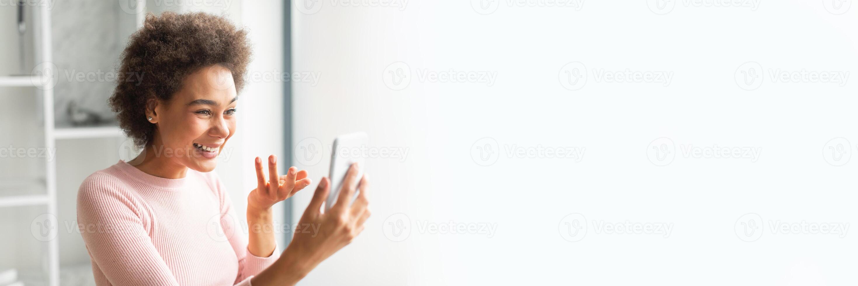 Joyful african american woman engaging with a tablet against a white background with plenty of copy space for a web-banner photo