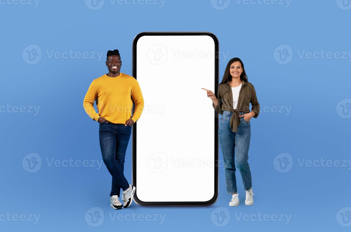 Cool multiethnic couple standing next to a massive telephone, looking curious and engaged. The phone is oversized, making them appear small in comparison. photo