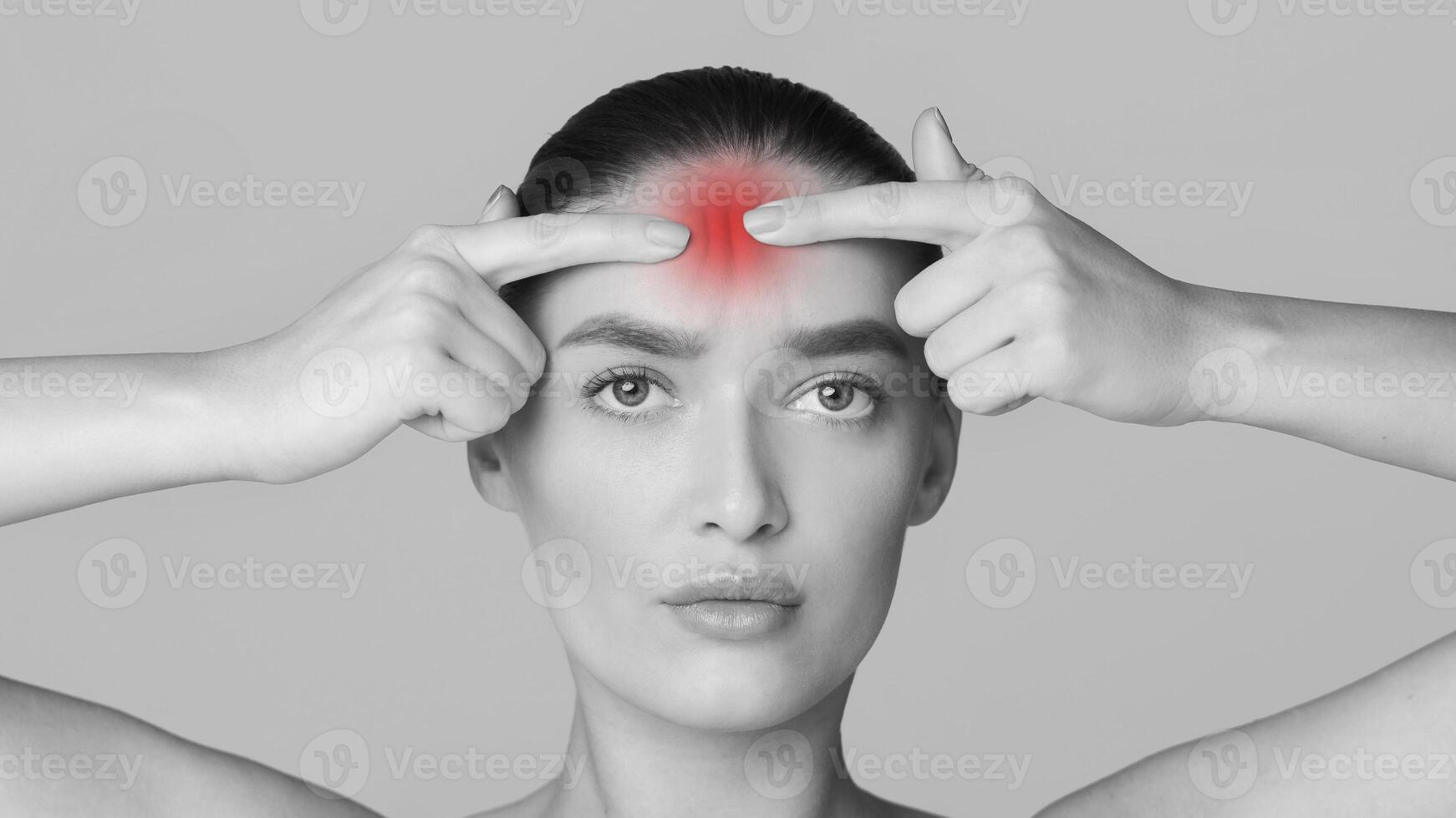 A woman with a noticeable red spot on her head. She appears to be standing in a room with a serious expression on her face. photo