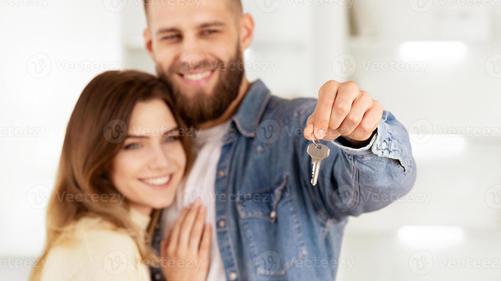 New Home Owners. Loving Couple Showing Key, Hugging And Smiling photo