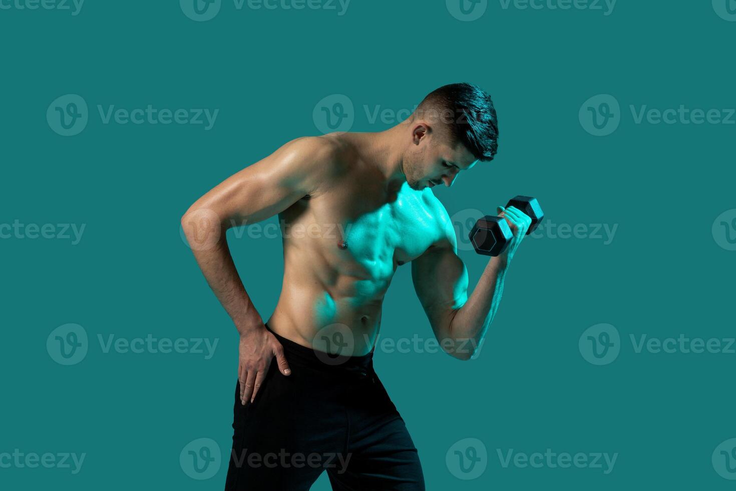 A man is lifting a dumbbell with one hand against a vibrant green background. He is focused and showing determination in his workout routine. photo