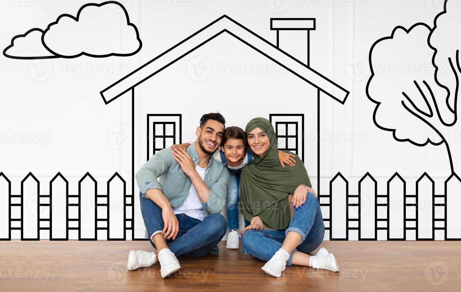 Loving middle eastern family father mother and daughter sitting over drawn on white wall house, embracing and smiling. Real estate, mortgage concept photo