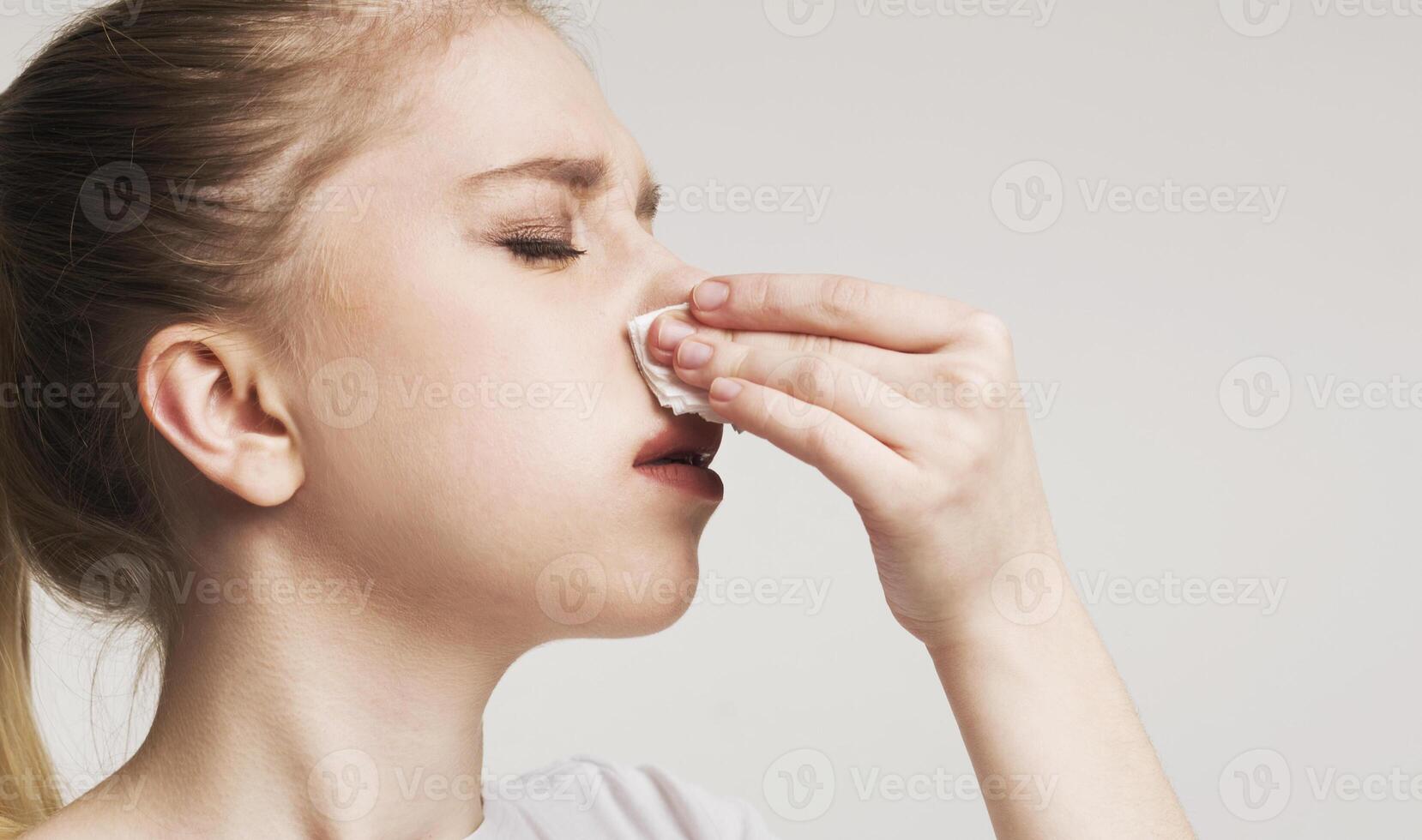 High blood pressure. Young woman suffering from nose bleeding, stop blood with tissue, free space photo