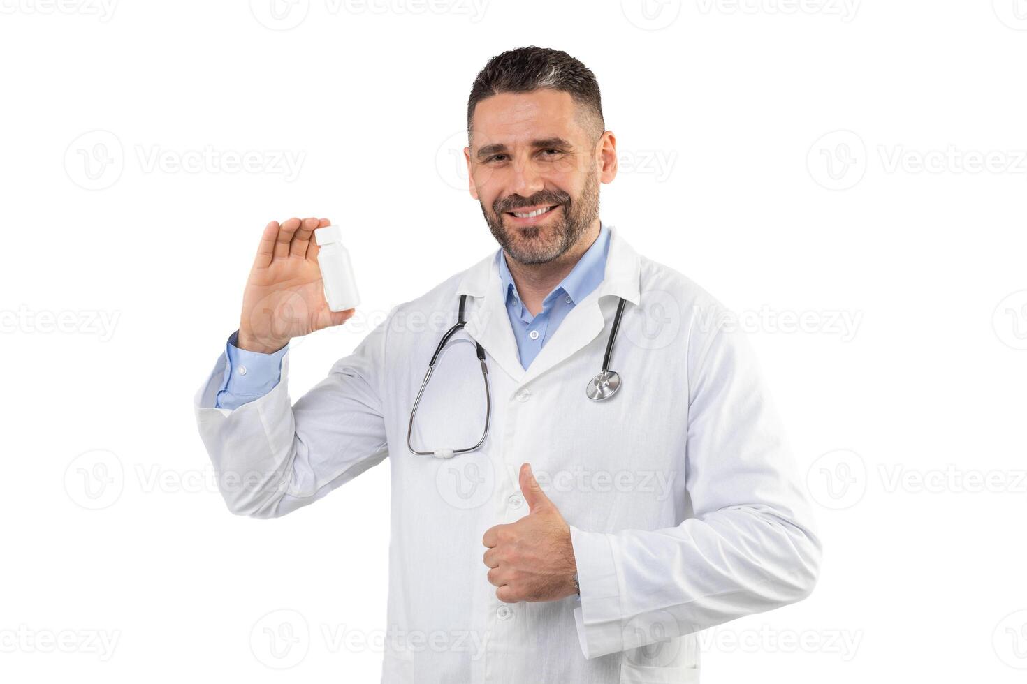 A man doctor with a stethoscope around neck smiles while holding a white medication bottle in one hand and giving a thumbs up with the other, conveying approval and confidence in a clinical setting. photo