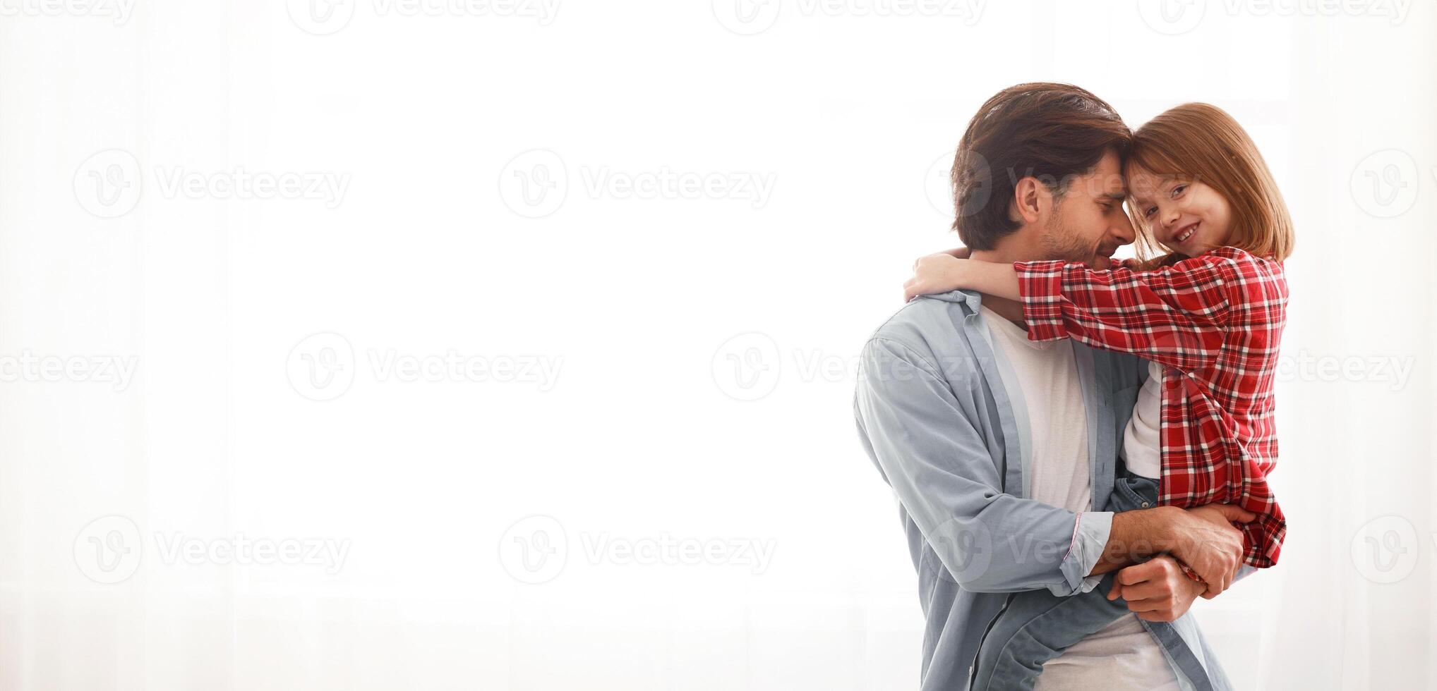 Loving daddy and daughter posing at home over big window, copy space photo
