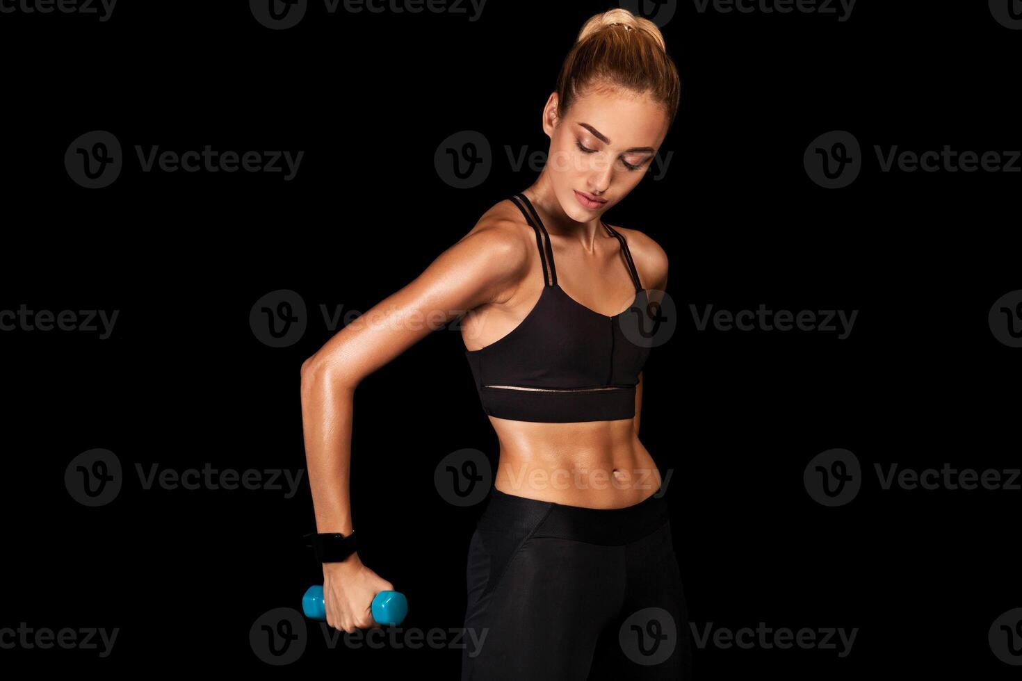 Determined Young Woman Working Out With Dumbbells On Black Studio Background. Strength Exercises. Copy Space photo