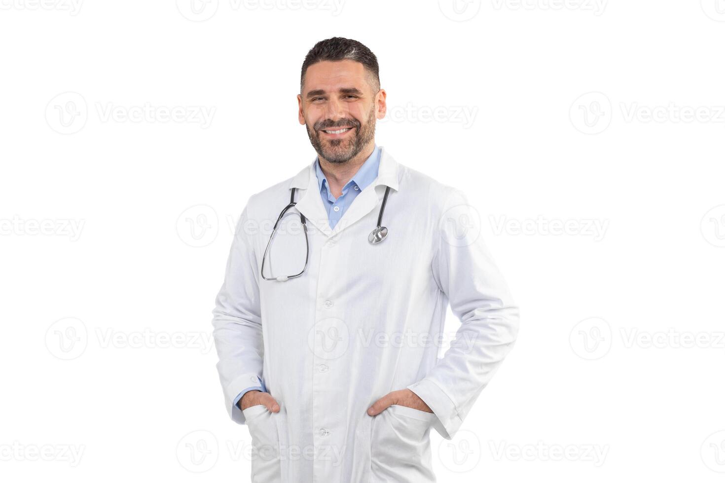 A smiling man doctor stands confidently with his hands in his pockets, wearing a white coat and stethoscope, against a plain white background in a studio. photo
