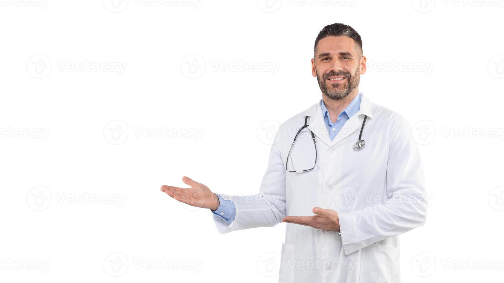 A man doctor, wearing a white lab coat and stethoscope, confidently gestures towards his right. He appears friendly and approachable, panorama with copy space photo