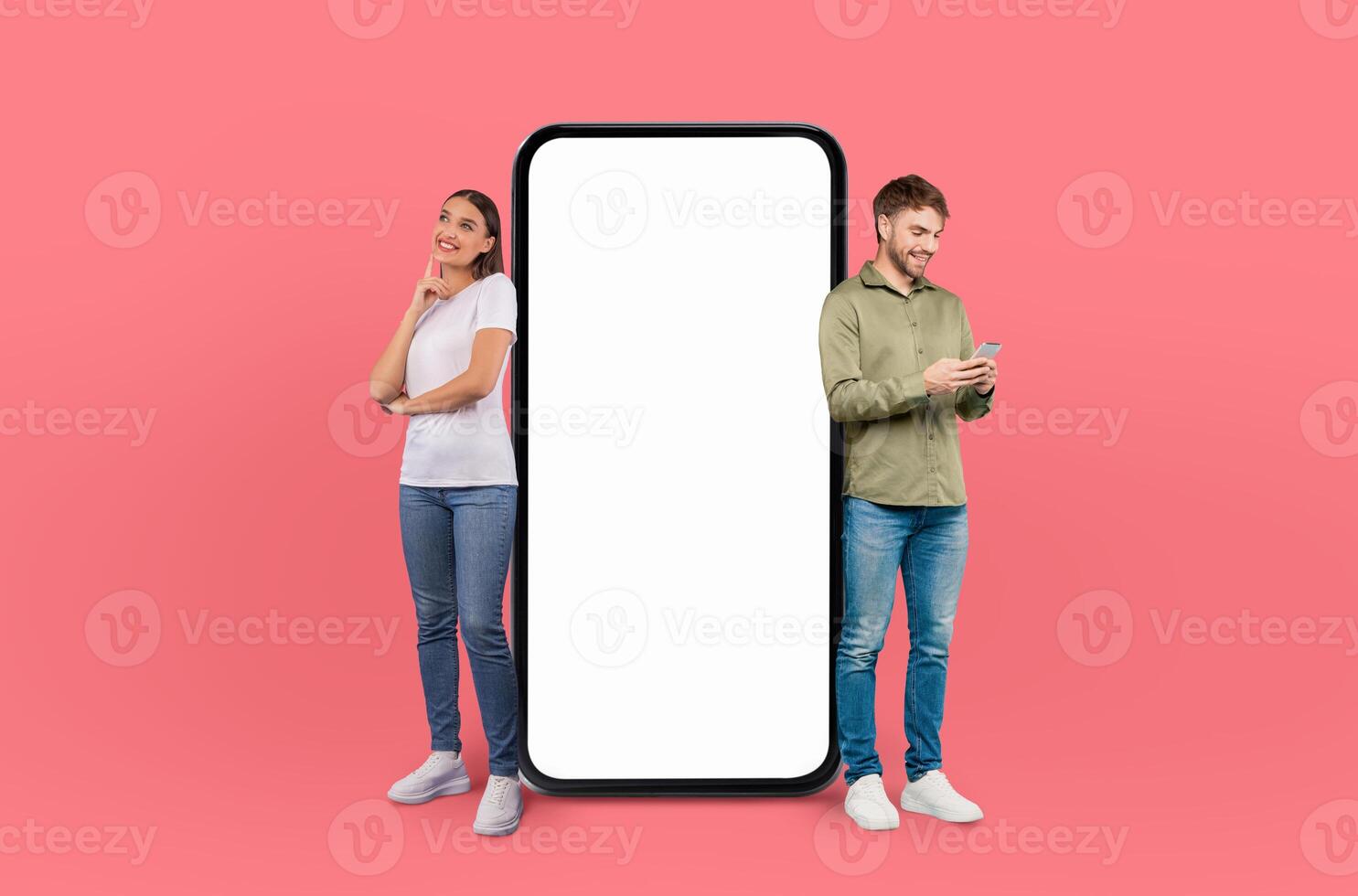 A man and a woman are depicted standing next to a large phone in this scene. They appear to be looking at the phone, possibly engaged in a conversation or using its features photo