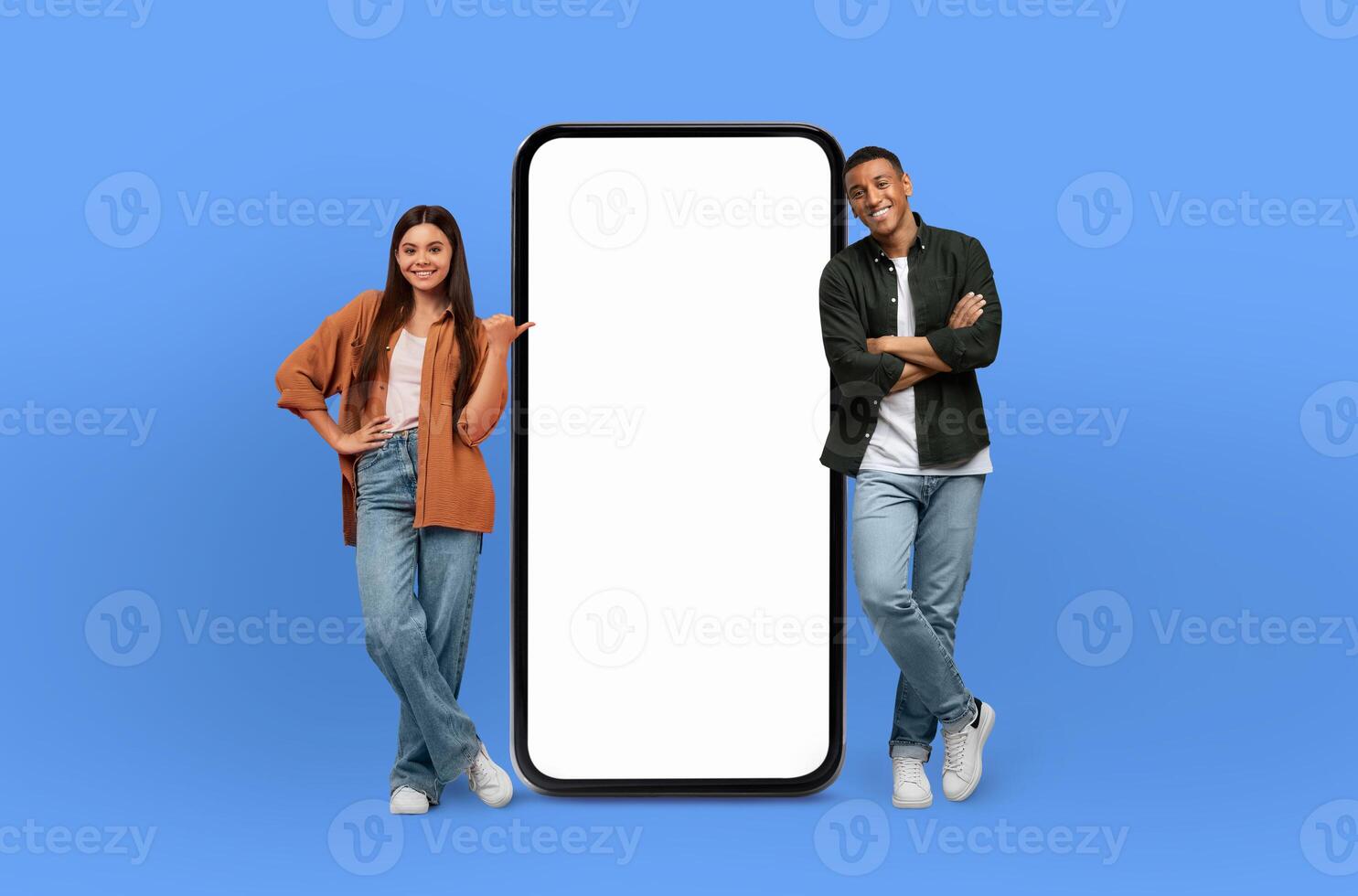 A man and a woman are standing next to a large screen phone, examining the display, woman is pointing at the phone screen, seemingly engaged in the content. photo
