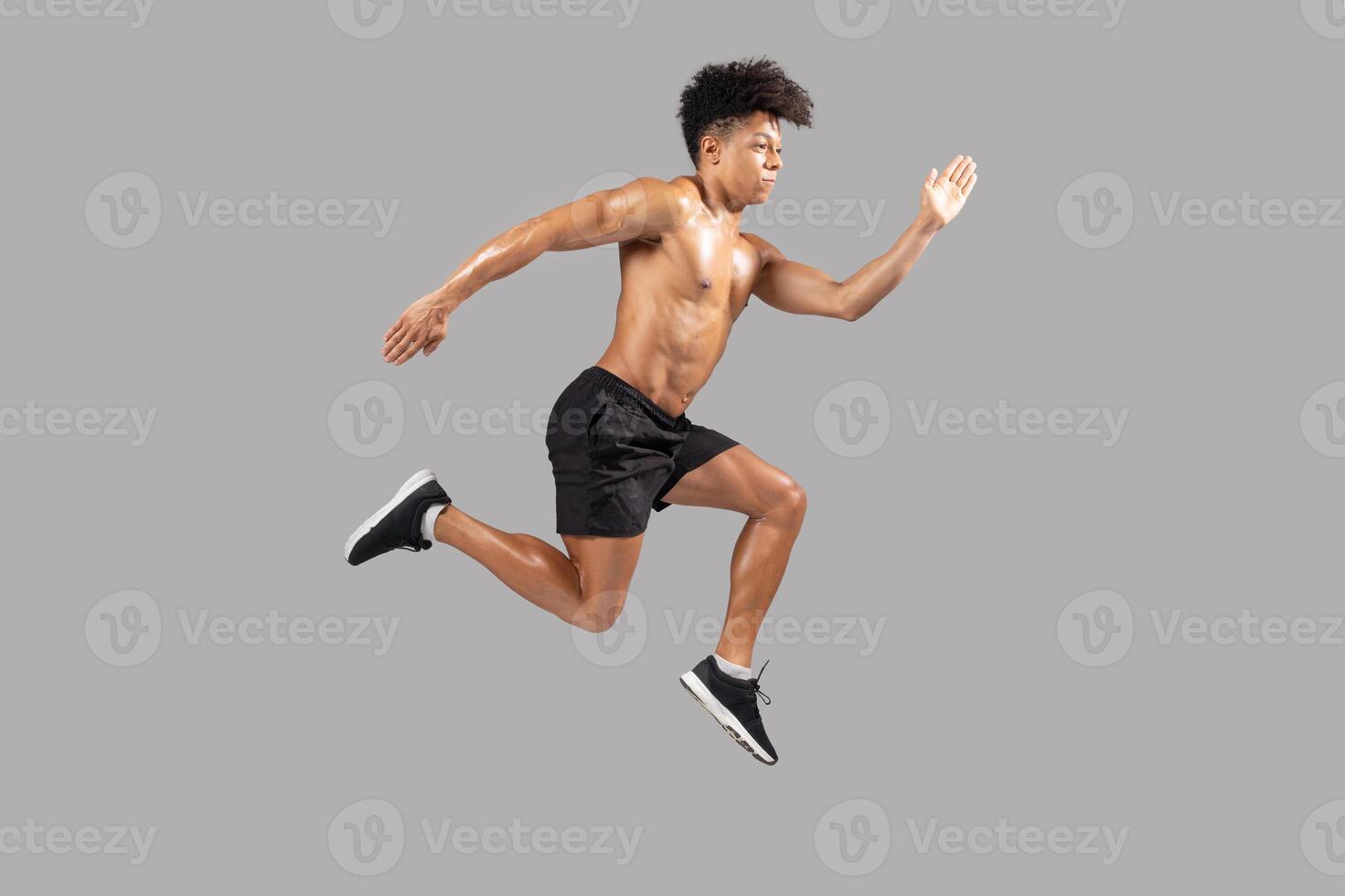A young man athlete demonstrates explosive energy while sprinting forward, showcasing strong muscles and athletic form. His determination is evident as he runs with impressive speed photo
