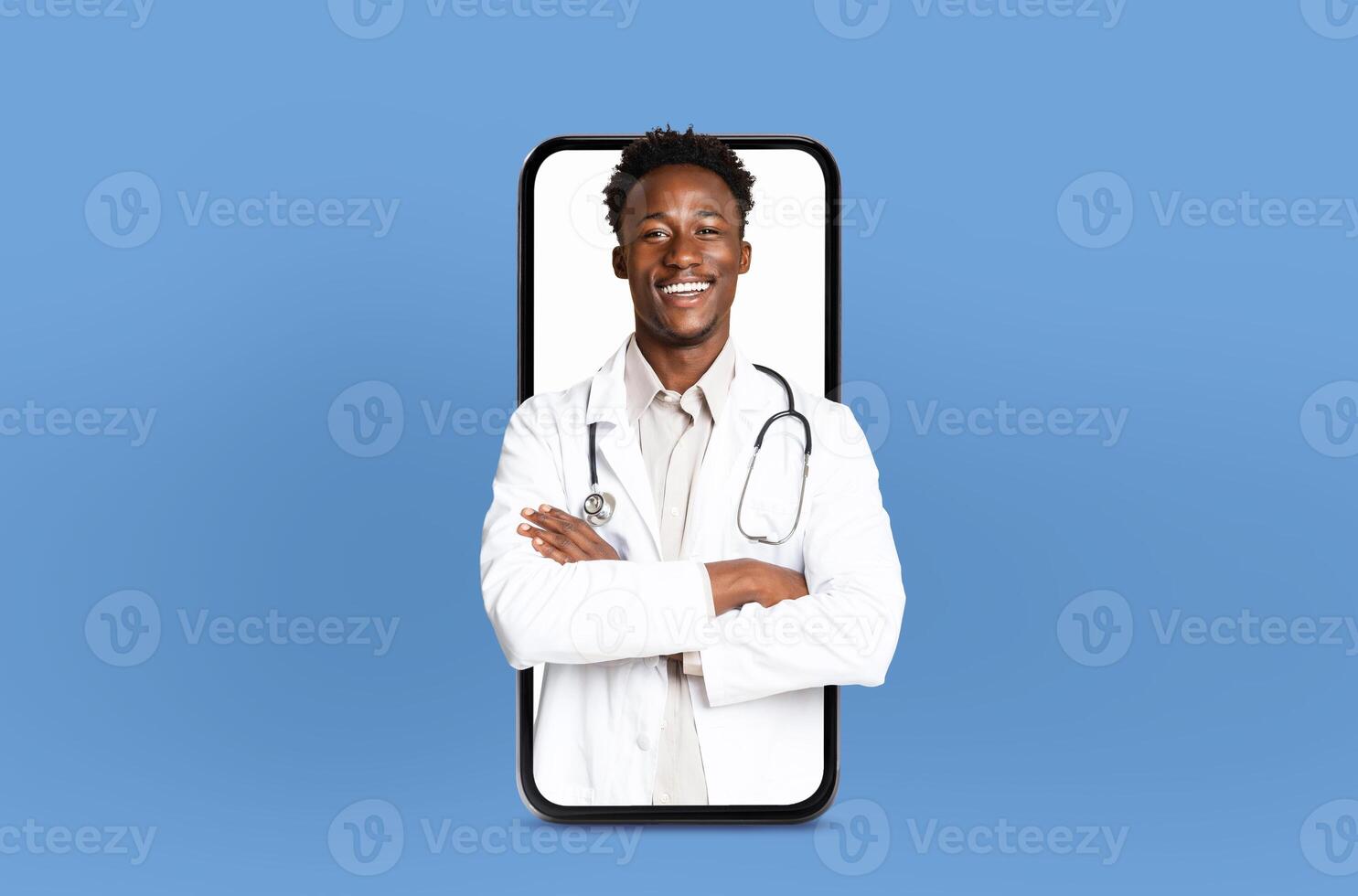 A black man doctor is attentively looking at his phone screen with a stethoscope attached, possibly checking medical information or communicating with colleagues. photo