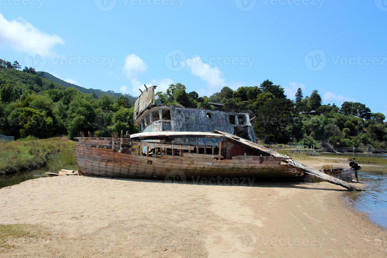 Old wooden wrecked ship on the shore. Light photo on a sunny day