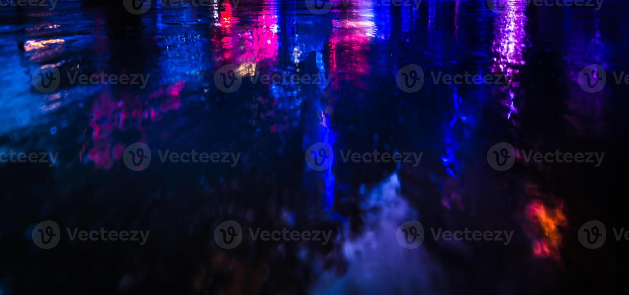 A blurry image of a city at night with colorful lights photo