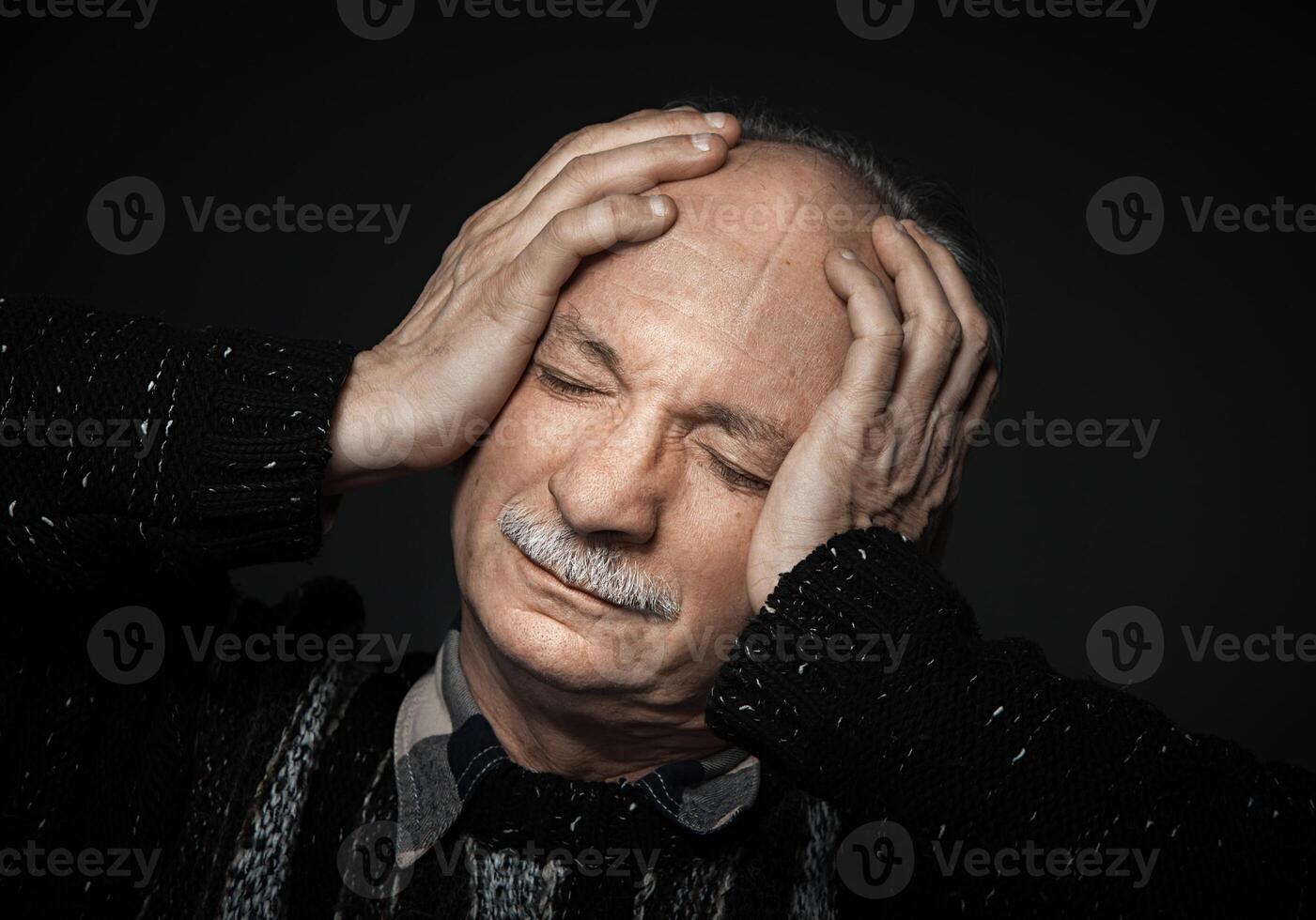 An older man with his hands on his head photo
