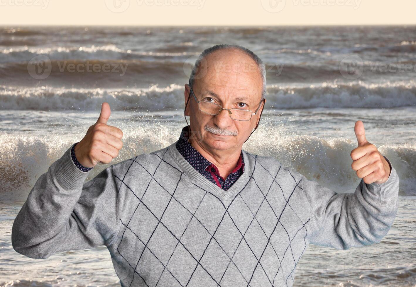 A man standing in front of the ocean giving a thumbs up photo
