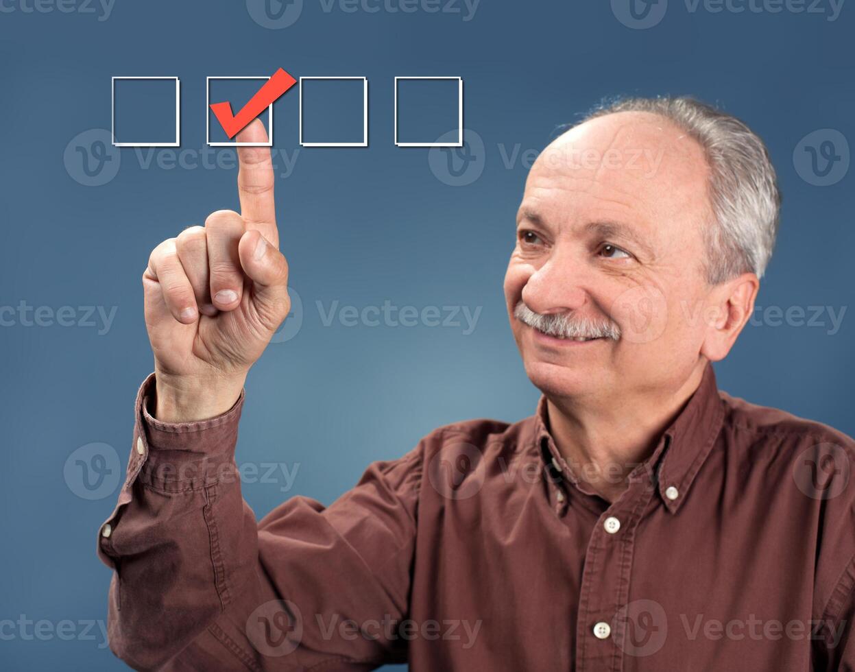An older man pointing to a check box photo