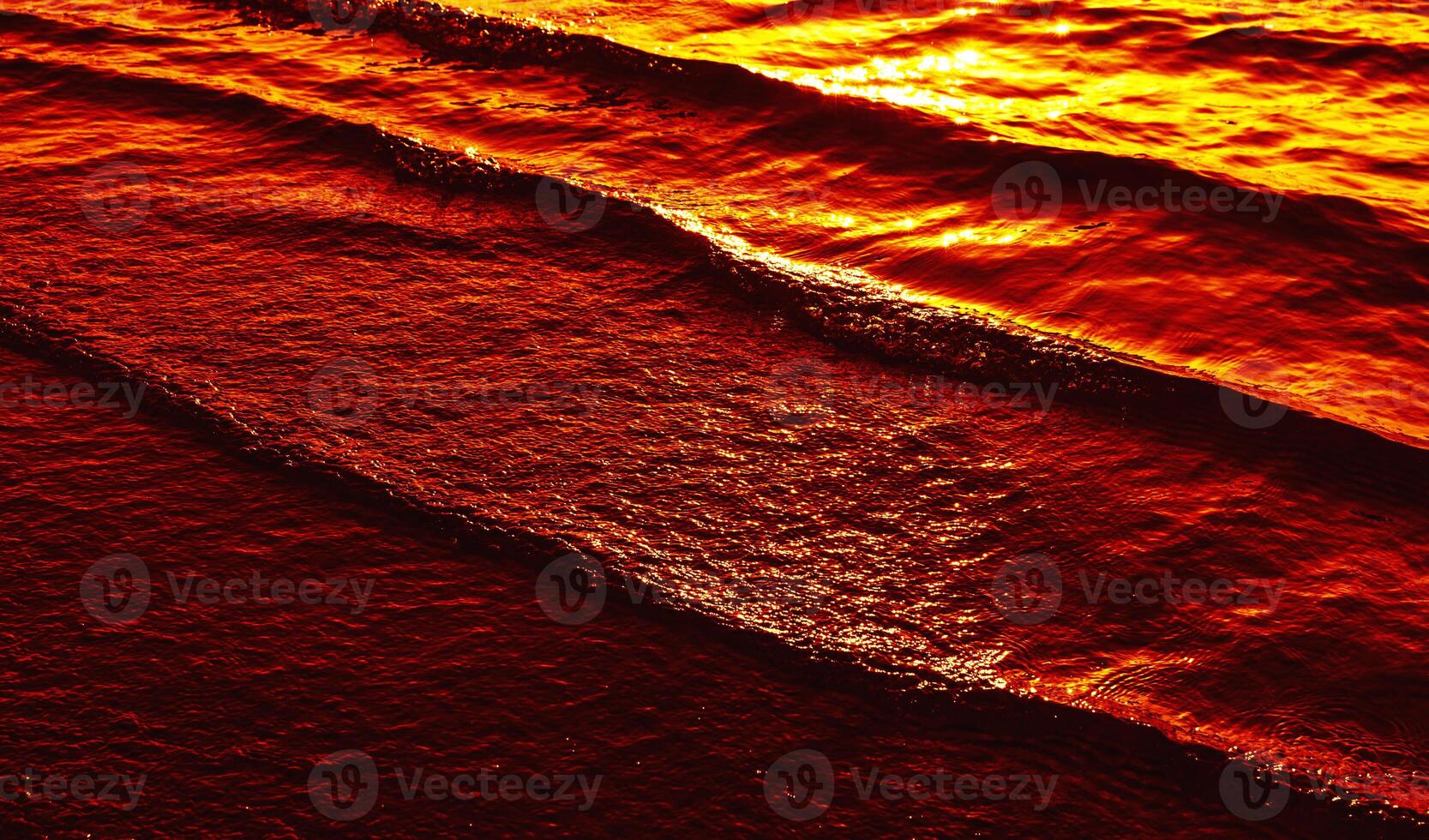 A person is surfing on the ocean at sunset photo