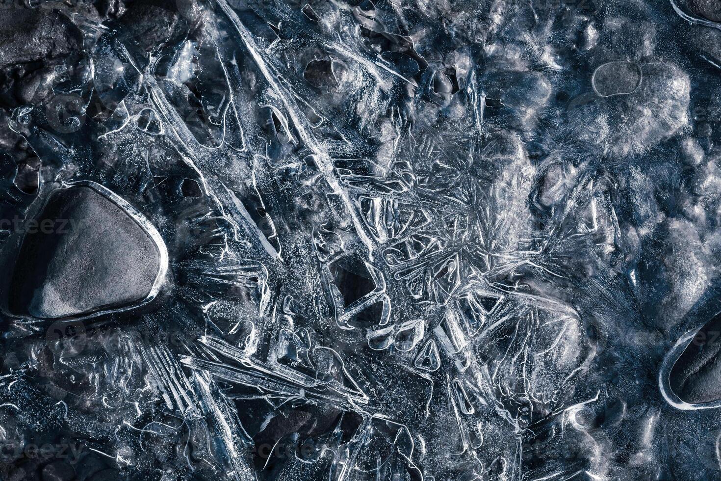 Nature background. Closeup image of ice patterns on the surface of frozen water photo