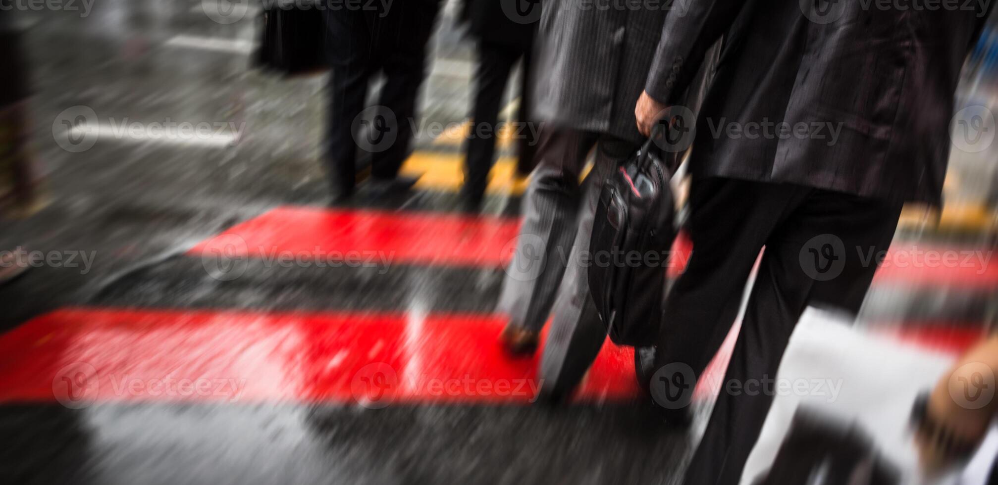 Blurry image of people walking on a street in the rain photo