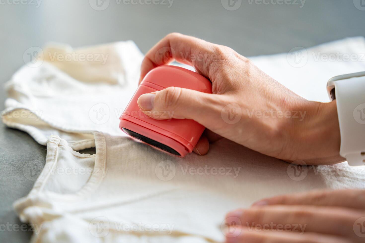 Close-up view of woman's hands with a stamp with a name for signing children's things. Identification of personal clothing. High quality photo