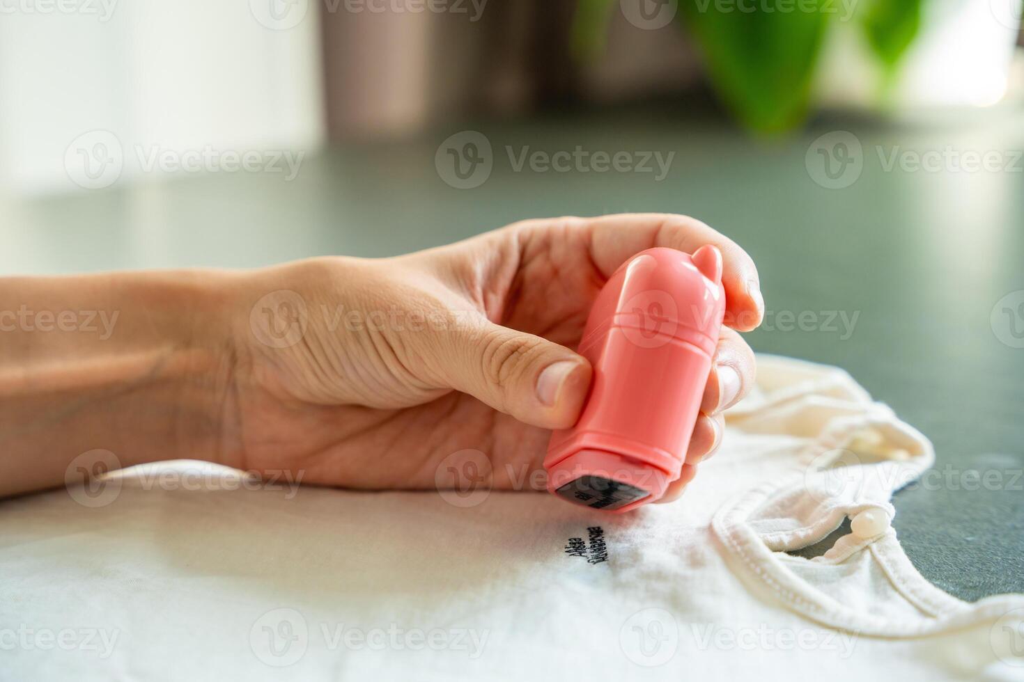 Close-up view of woman's hands with a stamp with a name for signing children's things. Identification of personal clothing. High quality photo