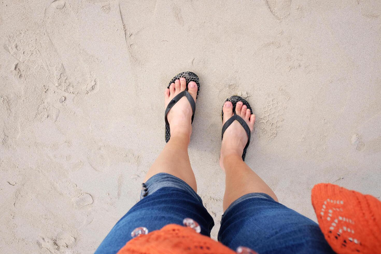Woman legs and feet with sandals walking on the beach. Summer in the sea travel photo