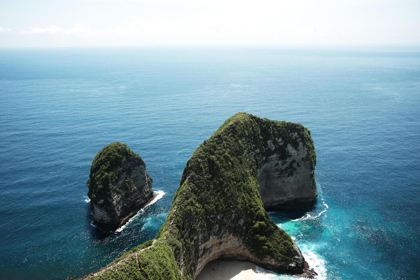 Landscape of wave crashing rocky cliff and wild on stone mountain. Destination blue calm sea and ocean on summer at Kelingking beach is famous place in Bali island at Indonesia photo