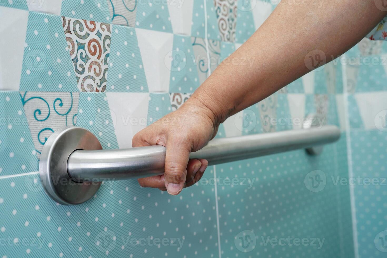 Asian elderly old woman patient use toilet support rail in bathroom, handrail safety grab bar, security in nursing hospital. photo
