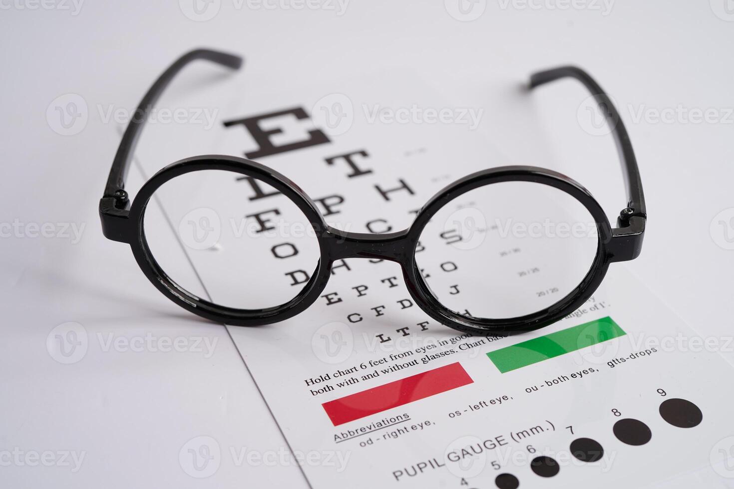 Glasses on eye exam chart to test eyesight accuracy of reading. photo