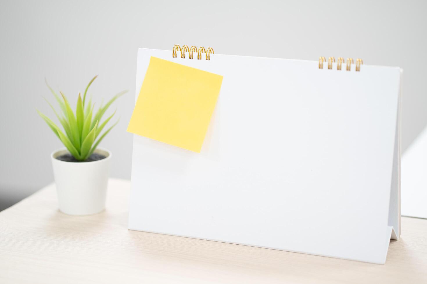 Yellow sticky notes on blank desk calendar at business office with copy space for text,selective color. photo